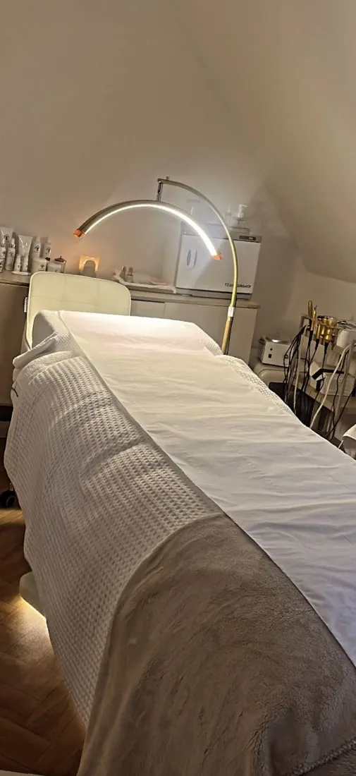 Treatment bed lit by a warm arched lamp
